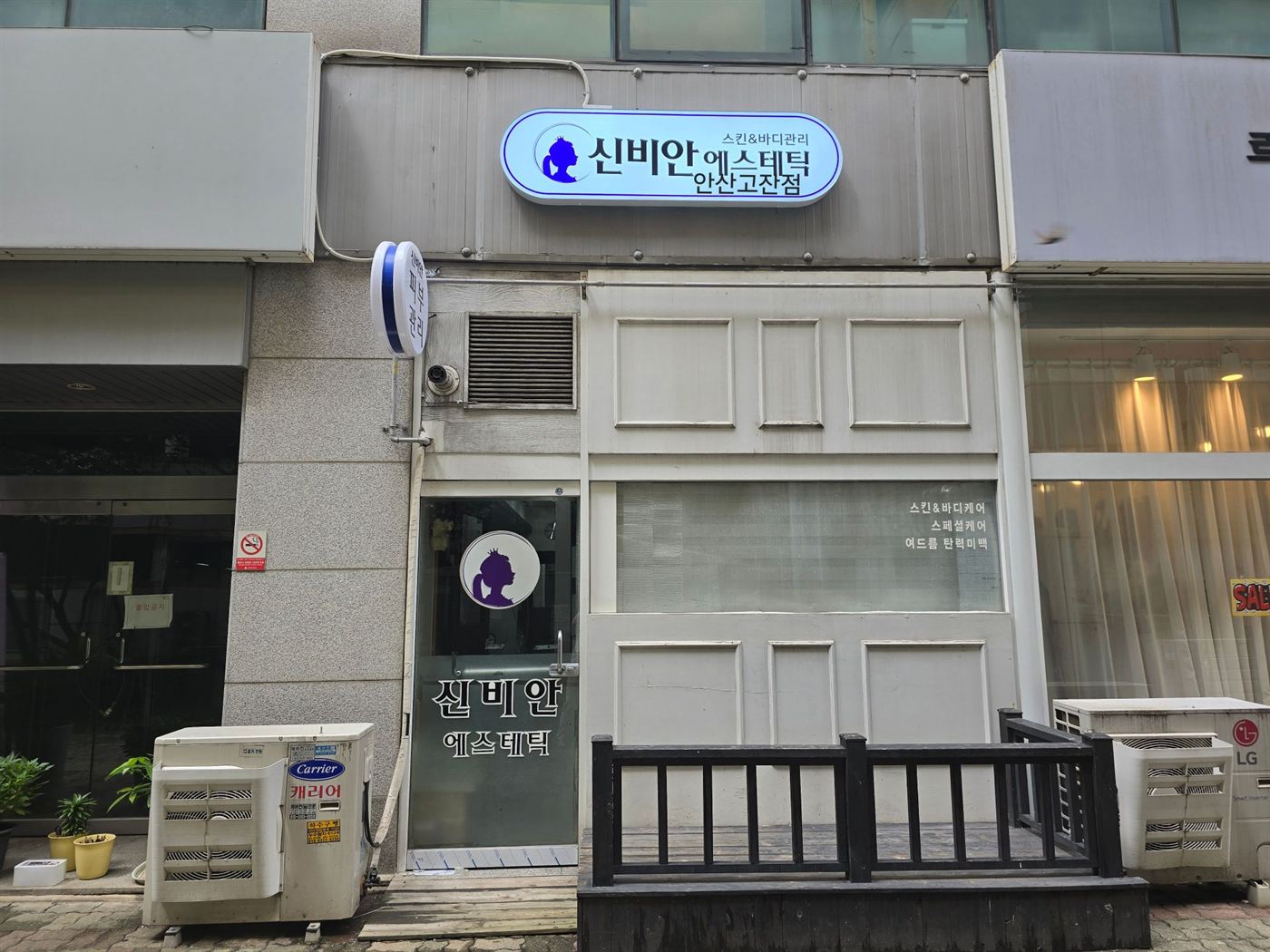 복도 반대쪽, 건물 사이로 난 쪽의 신비안 에스테틱 간판과 출입문